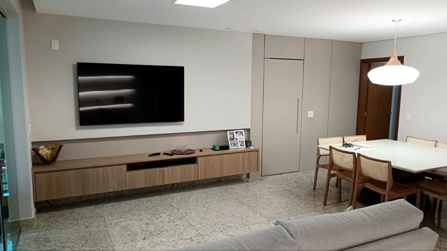 Sala integrada com painel de TV e móvel planejado
